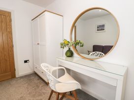 A bedroom with a mirror and table at Cae Sam in Pentraeth