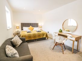 A bedroom with a bed, sofa, and desk at Cae Sam in Pentraeth