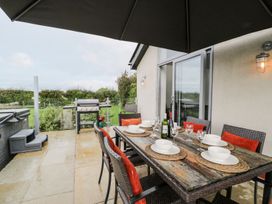 An outdoor dining area with a table and chairs at Cae Sam Pentraeth