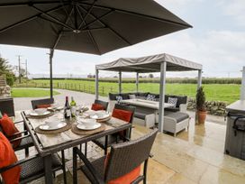 An outdoor dining area with a table and chairs at Cae Sam in Pentraeth