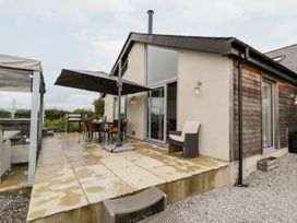 A patio with a table and chairs at Cae Sam in Pentraeth