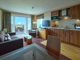 A living room with a sofa and kitchen area at Duplex Apartment Penrith