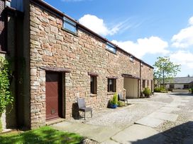 A stone building with a pathway and chairs at Skiddaw in Penrith