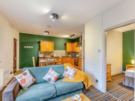 A living room with a sofa and kitchen area at Skiddaw in Penrith