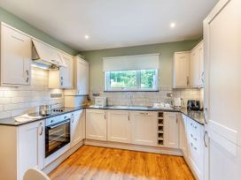A kitchen with cabinets and appliances at The Whitbarrow Den in Penrith