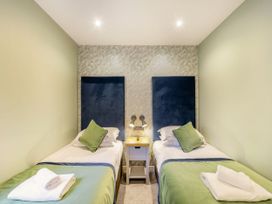 A bedroom with two beds and a nightstand at The Whitbarrow Den in Penrith