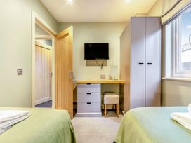 A bedroom with a desk and television at The Whitbarrow Den in Penrith