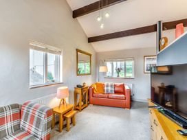 A living room with a sofa and TV at Caldew Cottage Spa in Penrith