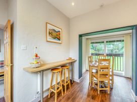 A dining room with a breakfast bar and table at Caldew Cottage Spa Penrith