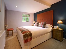 A bedroom with a bed and nightstands at Caldew Cottage Spa in Penrith