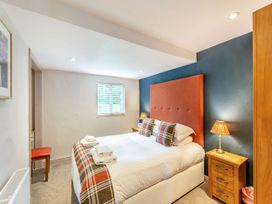 A bedroom with a bed and bedside lamps at Caldew Cottage Spa Penrith