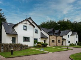 A row of houses with a pathway and garden at Troutbeck Cottage Spa in Penrith