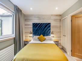 A bedroom with a bed and bedside table at Troutbeck Cottage Spa in Penrith