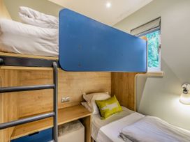 A bedroom with a bunk bed and bed in Troutbeck Cottage Spa Penrith