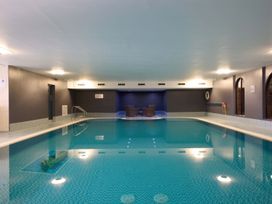 An indoor pool with seating area at Troutbeck Cottage Spa Penrith