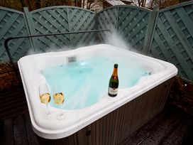 A hot tub with champagne and glasses at The Troutbeck Den Spa Penrith