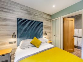 A bedroom with a bed and wardrobe at The Troutbeck Den Spa in Penrith