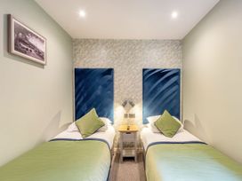 A bedroom with two beds and a nightstand at The Troutbeck Den Spa in Penrith