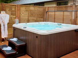 An outdoor area with a hot tub and wooden panel fence at The Farmhouse 2 Penrith