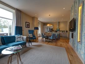 A living room with a sofa and dining area at The Farmhouse 2 in Penrith