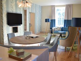 A living room with a television and seating area at The Farmhouse 2 Penrith