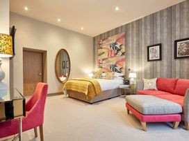 A bedroom with a bed and seating area at The Farmhouse 2 Penrith