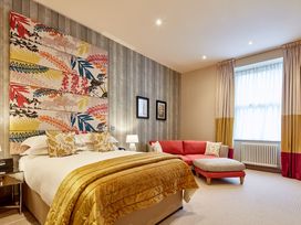 A bedroom with a bed and a couch at The Farmhouse 2 Penrith