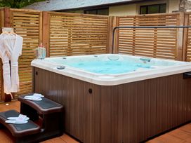 An outdoor area with a hot tub and bathrobes at The Farmhouse 1 in Penrith