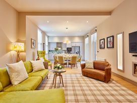 A living room with a sofa and dining area at The Farmhouse 1 Penrith