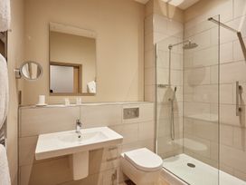 A bathroom with a shower, sink, and toilet at The Farmhouse 1 Penrith