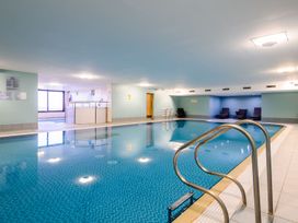 An indoor pool area with a swimming pool and seating at The Farmhouse 1 Penrith