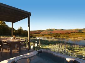 An outdoor space with a table and chairs by a river at Peak View in Penrith