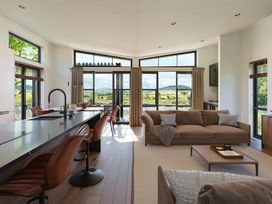A living room with a sofa and kitchen island at Peak View in Penrith