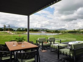 An outdoor seating area with a table and chairs overlooking a lake at Wansfell in Penrith