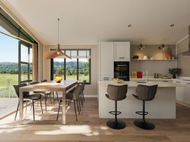 A kitchen with a dining table and bar stools at Fell Side in Penrith