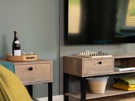 A living room with a TV, chess set, and drinks at Patterdale (Pet) Penrith