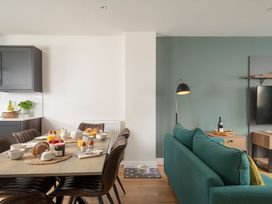 A dining area with a table set for breakfast and a living area with a sofa at Patterdale (Pet) Penrith