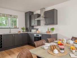 A kitchen with cabinets and dining table at Patterdale (Pet) Penrith
