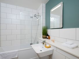 A bathroom with a bathtub, sink and mirror at Patterdale (Pet) Penrith
