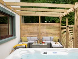 An outdoor seating area with a hot tub and a table at Patterdale (Pet) in Penrith