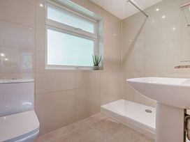 A bathroom featuring a toilet, sink, shower, and window at Klys 1.0 Spa Perranporth