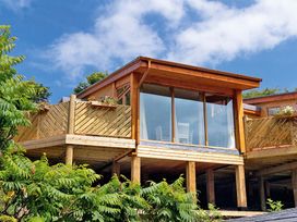 A modern building with a balcony and glass doors at Piran Spa Lodge Pet in Perranporth