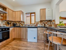 A kitchen with cabinets, countertop, dishwasher, and window at Piran Spa Lodge Pet Perranporth