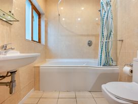 A bathroom with a bathtub, toilet, and sink at Piran Spa Lodge Pet in Perranporth