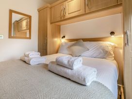 A bedroom with a large bed and towels at Chapel Rock Spa Pet Perranporth
