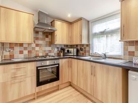 A kitchen with wooden cabinets and a countertop at Chapel Rock Spa Pet in Perranporth