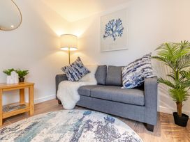 A living room with a sofa and lamp at Chapel Rock Spa Pet in Perranporth