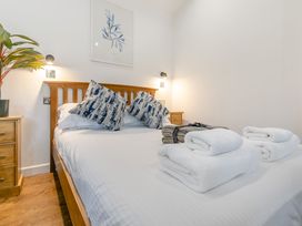 A bedroom with a bed and towels at Droskyn Spa Pet Perranporth