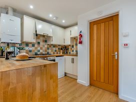 A kitchen with cabinets, sink, and stove at Poldark Spa Pet in Perranporth
