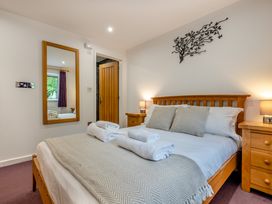 A bedroom with a double bed and wooden furniture at Poldark Spa Pet in Perranporth